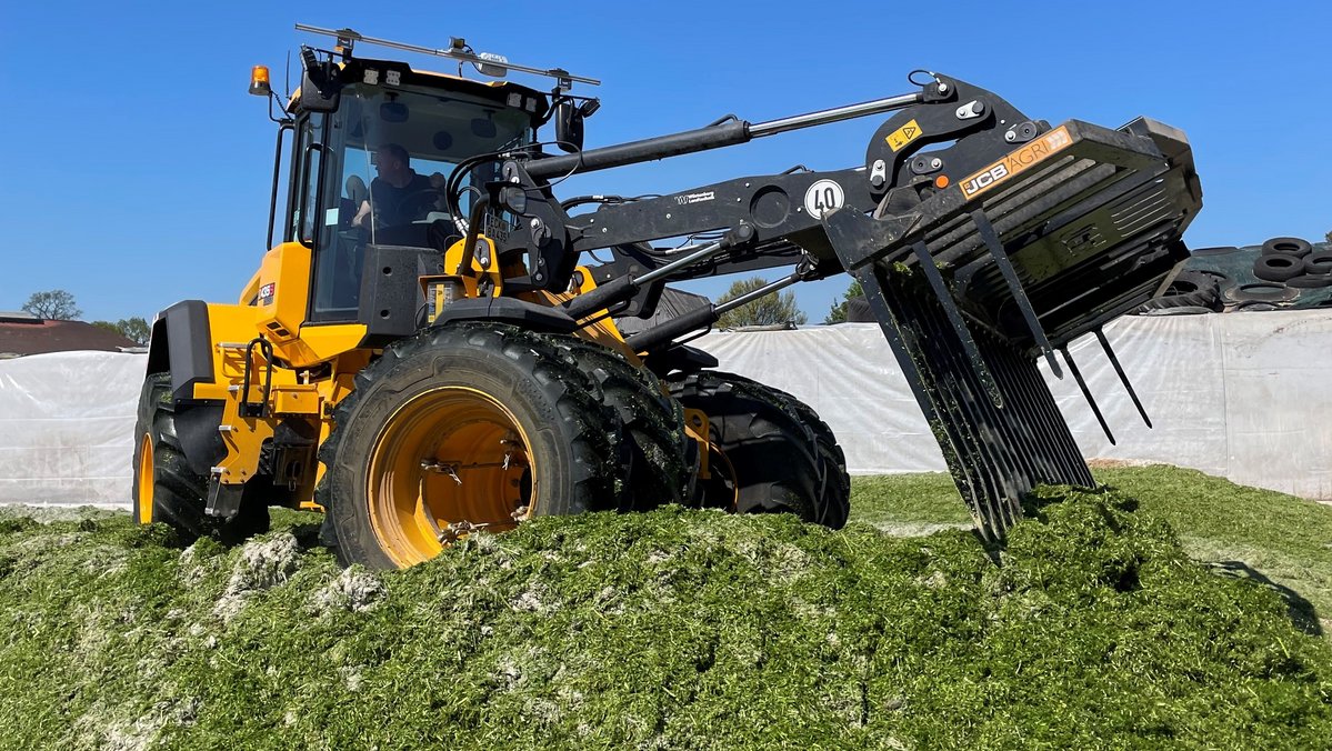 Die Grassilage wird mit einer Maschine verdichtet.